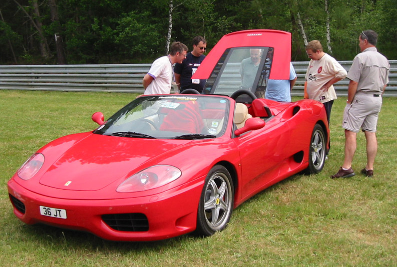 Ah, a Ferrari. What is the bloke on the right doing in his pocket? Dirty man. It's onl;y a Ferrari!